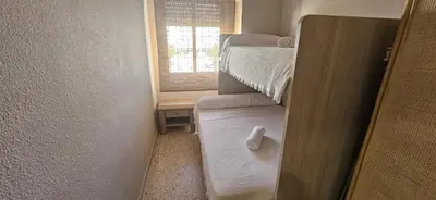 a small room with two bunk beds and a window at Valparaiso Arenas in El Puerto de Santa María