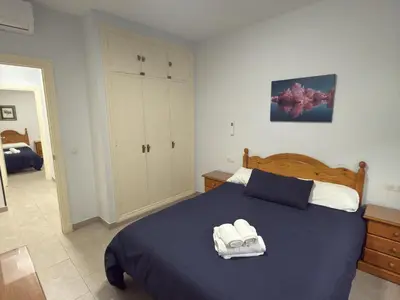 a bedroom with a blue bed with two towels on it at García Rota Beach by staycare in Rota