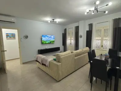 a living room with a couch and a television on the wall at García Rota Beach by staycare in Rota