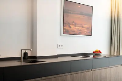a kitchen with a black counter top and a picture at AvantiStays Porta Coeli con PARKING GRATIS in Sanlúcar de Barrameda