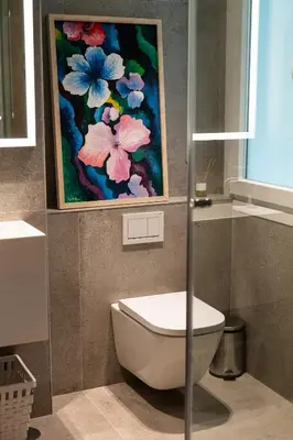 a bathroom with a toilet and a painting on the wall at AvantiStays Porta Coeli con PARKING GRATIS in Sanlúcar de Barrameda