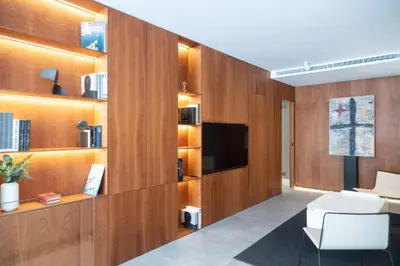 a living room with wooden cabinets and a television at AvantiStays Porta Coeli con PARKING GRATIS in Sanlúcar de Barrameda