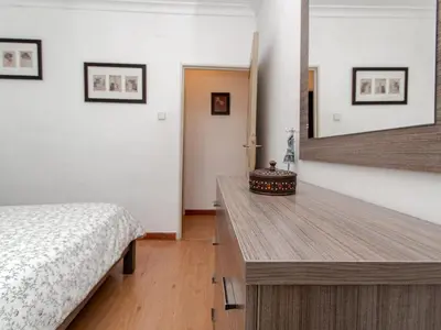 a bedroom with a bed and a wooden table at Winahost El Rincon del Puerto in El Puerto de Santa María