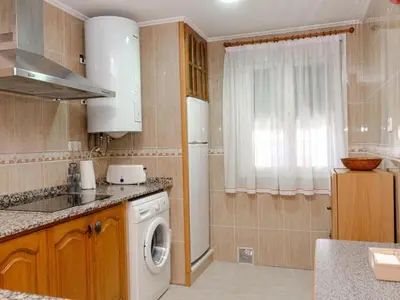 a kitchen with a washing machine and a window at Winahost El Rincon del Puerto in El Puerto de Santa María