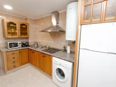 a kitchen with a washer and a white refrigerator at Winahost El Rincon del Puerto in El Puerto de Santa María