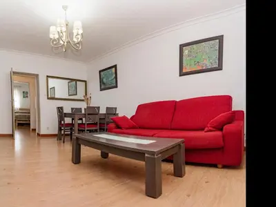 a living room with a red couch and a table at Winahost El Rincon del Puerto in El Puerto de Santa María