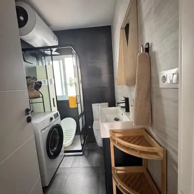 a bathroom with a sink and a washing machine at Apartamento cerca del paseo marítimo in Rota