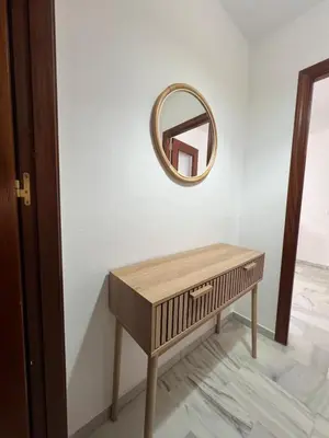 a dressing table with a mirror on a wall at Apartamento Relax Centro in Sanlúcar de Barrameda