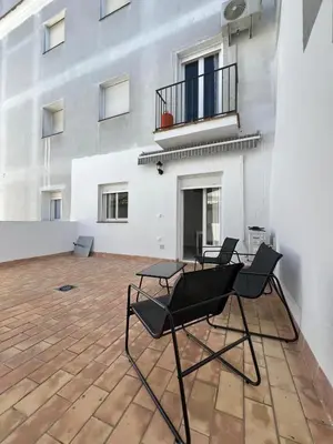 a group of chairs sitting on a patio in front of a building at Apartamento Relax Centro in Sanlúcar de Barrameda