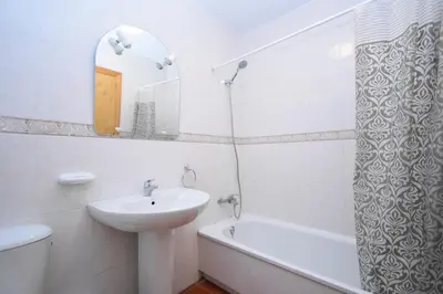 a bathroom with a sink and a toilet and a mirror at Dúo de bajos con jardín, juntos y climatizados en Aldea del Coto in Novo Sancti Petri