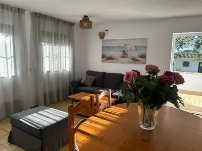 a bedroom with a large bed with a brown blanket at Villa Palmeras in Conil de la Frontera