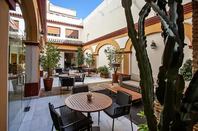 an outdoor patio with a table and chairs and a building at Hotel Barrameda in Sanlúcar de Barrameda