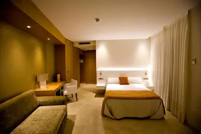 a hotel room with a bed and a couch at Hotel Barrameda in Sanlúcar de Barrameda