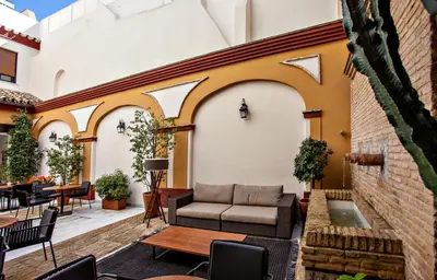 a patio with a couch and tables and chairs at Hotel Barrameda in Sanlúcar de Barrameda