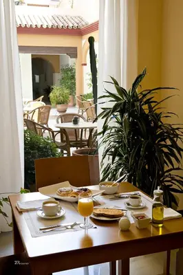 a table with plates of food and glasses of orange juice at Hotel Barrameda in Sanlúcar de Barrameda