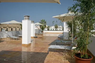 a patio with tables and chairs and umbrellas at Hotel Barrameda in Sanlúcar de Barrameda