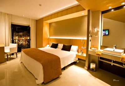 a bedroom with a bed and a sink and a mirror at Hotel Barrameda in Sanlúcar de Barrameda