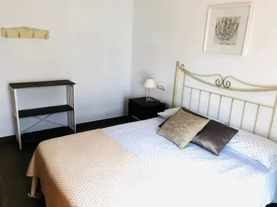 a bedroom with a bed and a table with a lamp at casa jaramar in Sanlúcar de Barrameda