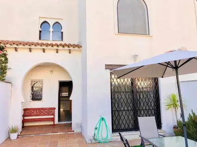 a patio with a table and an umbrella at casa jaramar in Sanlúcar de Barrameda