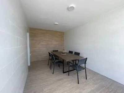 a dining room with a wooden table and chairs at Jaimar12 in Novo Sancti Petri