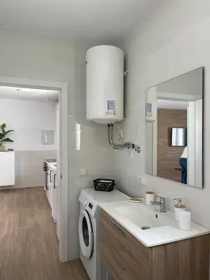 a bathroom with a sink and a washing machine at Jaimar12 in Novo Sancti Petri