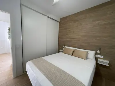 a bedroom with a large bed and a wooden wall at Jaimar12 in Novo Sancti Petri