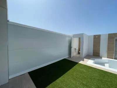 a bathroom with white walls and a green rug at Jaimar12 in Novo Sancti Petri