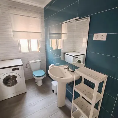 a bathroom with a sink and a washing machine at Casa Álamo in Puerto Real