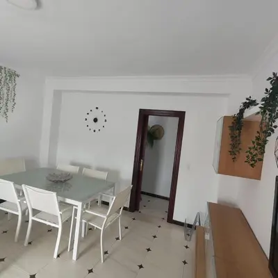 a dining room with a table and white chairs at Casa Álamo in Puerto Real