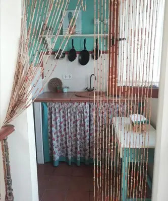 a kitchen with a counter and a table with utensils at Ático Vicario 11 in El Puerto de Santa María