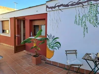 a mural on the side of a building with a plant at Ático Vicario 11 in El Puerto de Santa María