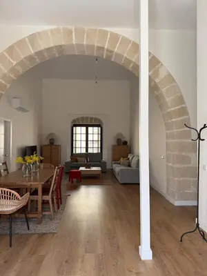 a living room with a table and an archway at ESPECTACULAR PISO EN PALACIO Preferiblemente familias y mayores de treinta años in El Puerto de Santa María