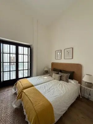 a bedroom with a large bed with a yellow blanket at ESPECTACULAR PISO EN PALACIO Preferiblemente familias y mayores de treinta años in El Puerto de Santa María