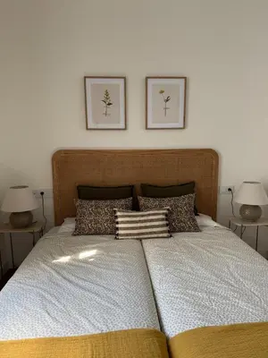 a bedroom with a large bed with two pictures on the wall at ESPECTACULAR PISO EN PALACIO Preferiblemente familias y mayores de treinta años in El Puerto de Santa María
