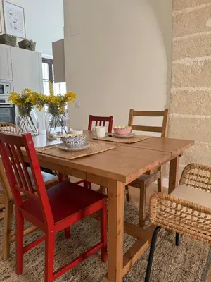 a wooden dining room table with red chairs at ESPECTACULAR PISO EN PALACIO Preferiblemente familias y mayores de treinta años in El Puerto de Santa María