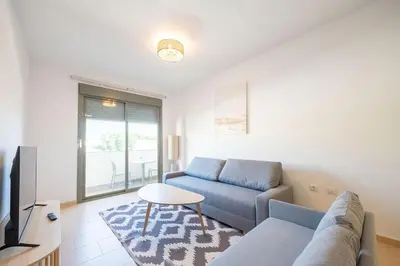a living room with a blue couch and a table at Centro con piscina y cerca de la estación de tren in El Puerto de Santa María