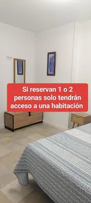 a sign in a bedroom with a bed in a room at Apartamento Prieta in Jerez de la Frontera