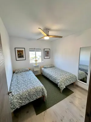 a bedroom with two beds and a ceiling fan at Atreb San Fernando in San Fernando