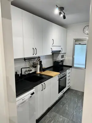 a kitchen with white cabinets and a black sink at Atreb San Fernando in San Fernando