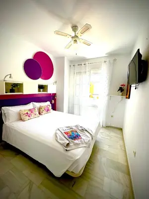 a bedroom with a white bed with a ceiling fan at MyChoice La Forestal in Rota