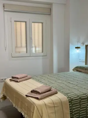a bedroom with a bed with two towels on it at Apartamento Guadalquivir 34 in Sanlúcar de Barrameda