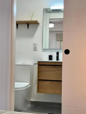 a bathroom with a toilet and a sink and a mirror at Apartamento Guadalquivir 34 in Sanlúcar de Barrameda