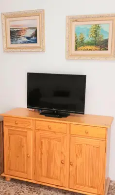 a flat screen tv sitting on top of a wooden cabinet at Villa Caheta in Chipiona