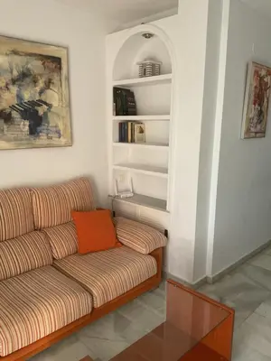 a living room with a couch and a book shelf at Casa Marejada in Puerto Real