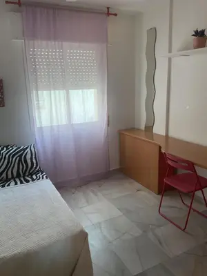 a bedroom with a bed and a desk and a chair at Casa Marejada in Puerto Real