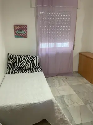 a small bedroom with a bed and a window at Casa Marejada in Puerto Real