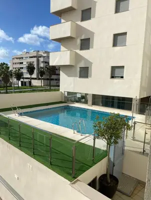 a swimming pool in front of a building at Refugio del Atlántico in El Puerto de Santa María
