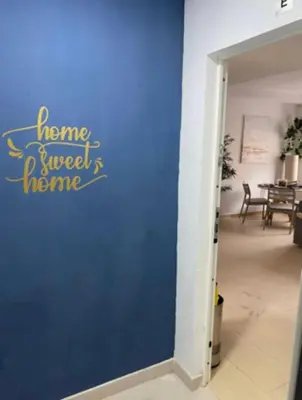 a blue wall with the words home sweet home written on it at Refugio del Atlántico in El Puerto de Santa María