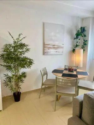 a living room with a table and chairs and a plant at Refugio del Atlántico in El Puerto de Santa María