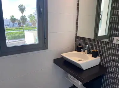a bathroom with a white sink and a mirror at Refugio del Atlántico in El Puerto de Santa María